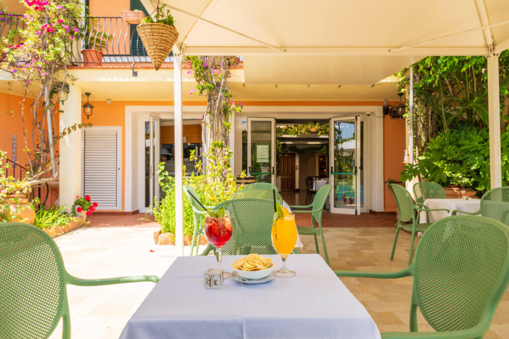 Galleria - Un aperitivo su un tavolo nell'area esterna del bar dell'hotel Domus de Janas