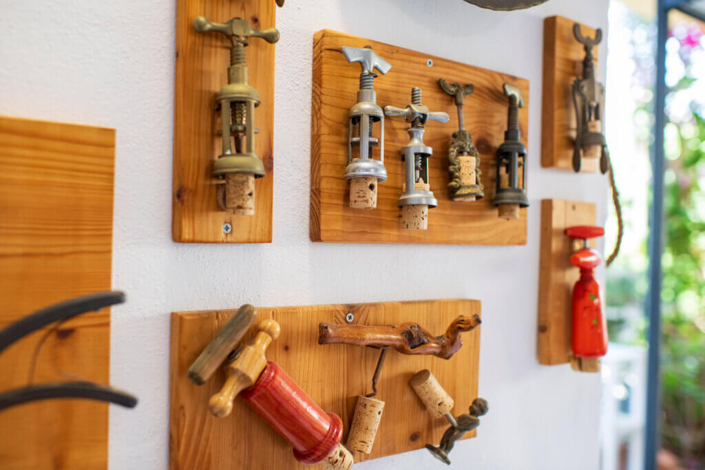 Galleria - Particolare della sala interna del ristorante Il Pesciolino dell'Hotel Domus de Janas con vecchi apribottiglie