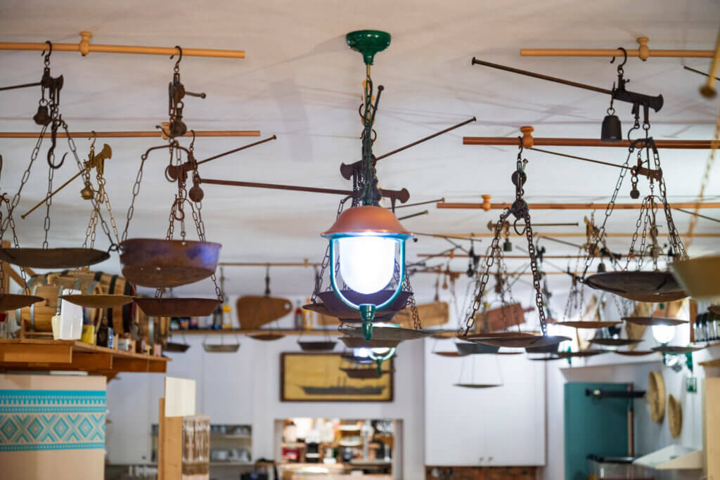 Galleria - Particolare della sala interna del ristorante Il Pesciolino dell'Hotel Domus de Janas decorata con vecchie bilance