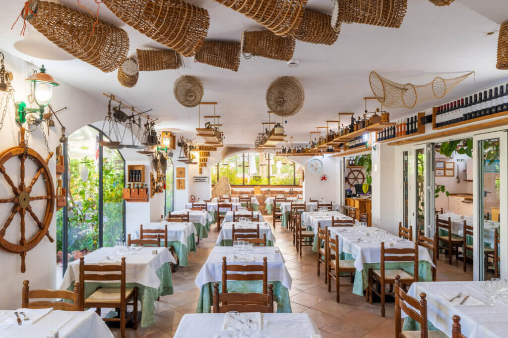 Galleria - Vista della sala interna del ristorante Il Pesciolino dell'Hotel Domus de Janas decorata da vecchie trappole di pescatori