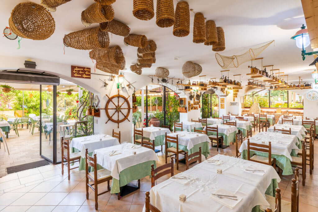Galleria - Vista della sala interna del ristorante Il Pesciolino dell'Hotel Domus de Janas decorata da vecchie trappole di pescatori