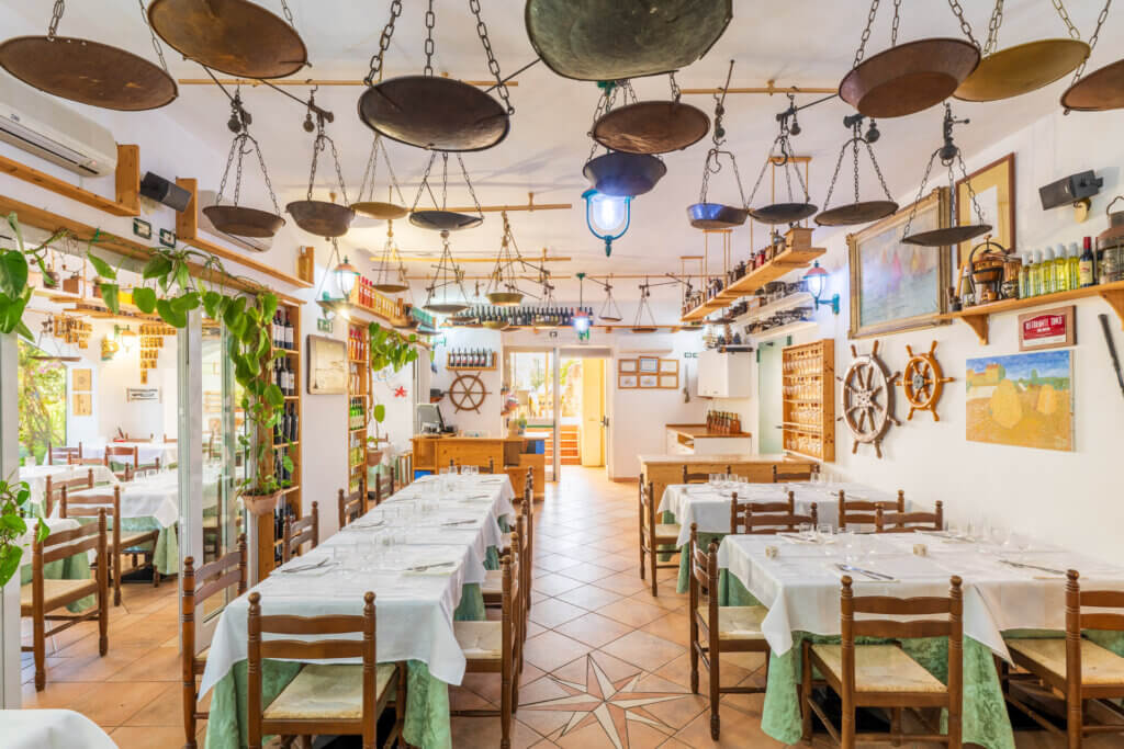 Galleria - Vista della sala interna del ristorante Il Pesciolino dell'Hotel Domus de Janas decorata con vecchie bilance